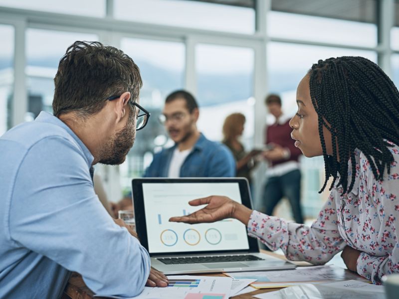 To personer diskuterer strategi og nettsideanalyse, engasjert i samtale rundt optimalisering av nettsider.