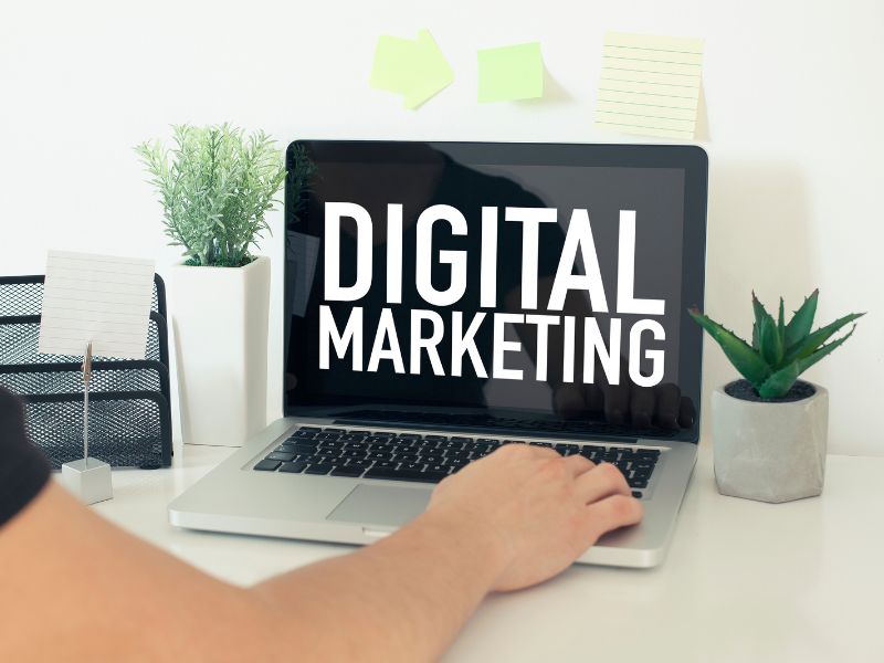 Hånd på tastatur på skjerm med tekst "Digital markedsføring", symboliserer enkel og effektiv online markedsføring.